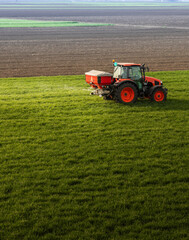 Fototapeta premium Farmer fertilizing arable land with nitrogen fertilizer