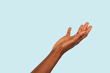An outstretched hand reaching toward the sky against a soft blue background, symbolizing hope and...