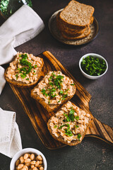 Bruschetta with mashed white beans and parsley on rye bread on a board vertical view