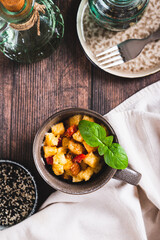 White bread pudding with egg, cheese and pepper in a cup on the table top and vertical view