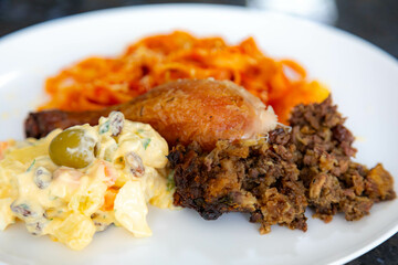 Traditional Brazilian Sunday lunch, pasta, roast chicken and mayonnaise salad with potatoes