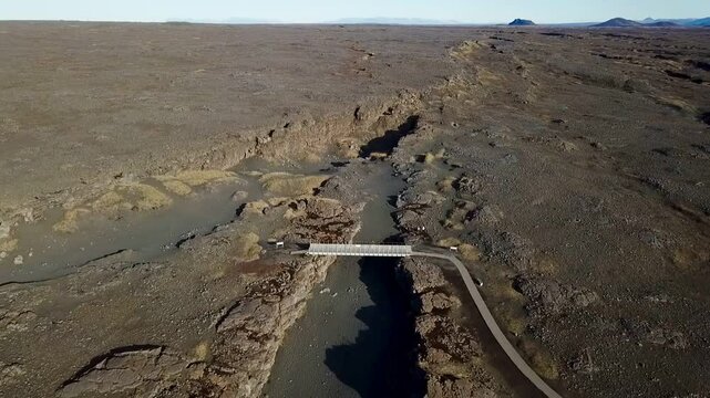 Aerial of the bridge connecting the north american and eurasian tectonic plates at Reykjanes, showcasing the dramatic rift between two major geological boundaries
