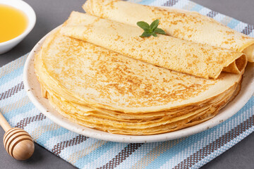 Stack of traditional russian pancakes blini on gray background with copy space. Homemade russian thin pancakes blini. Russian food, russian kitchen