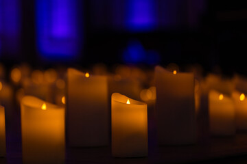 blurred symphonic orchestra on stage with lots of candles