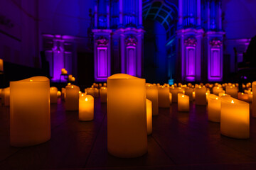blurred symphonic orchestra on stage with lots of candles