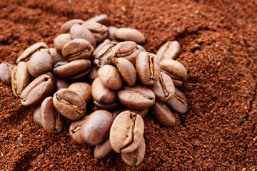 Coffee grains on ground coffee background
