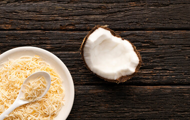 Dehydrated coconut flakes with sugar - Cocos nucifera in the bowl and spoon.