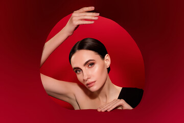 Photo of lady hold two ends hole in banner isolated on red background backdrop
