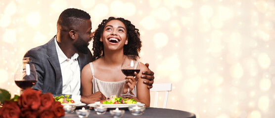 Romantic black man courting his pretty girlfriend while having valentine dinner in restaurant