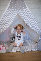 Adorable beautiful happy smiling ginger-haired toddler little girl is playing with her toys sitting...