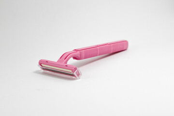 Disposable female pink razor on a white background. A tool to remove or trim hair from the skin. Female depilation and hygiene. Body care. Top view, copy space, stylish magazine concept