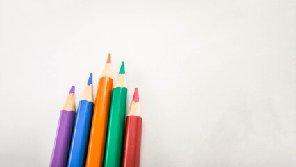 Colorful pencils arranged on white background 
