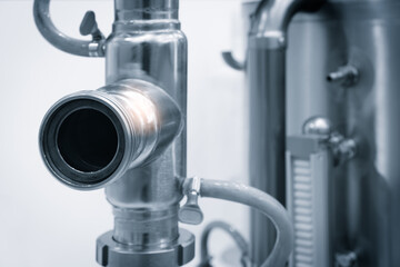 A silver pipe with a light on it. The pipe is bent in a way that it looks like it is being squeezed