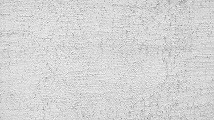 A white wall with a rough texture. The wall is covered in a white paint that has a grainy texture