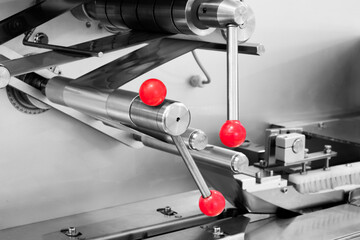 A machine with red buttons and a silver body. The machine is in motion and has a red and silver color scheme