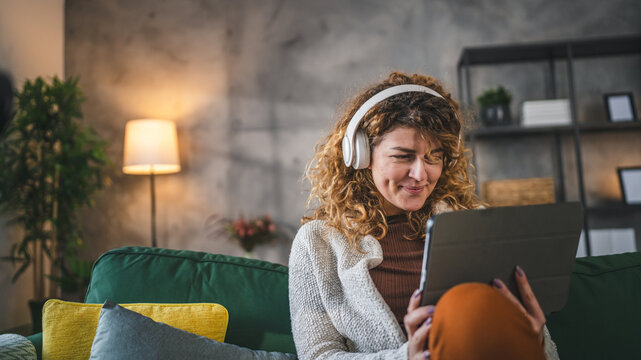 Woman sit at home use digital tablet to watch movie or have video call