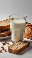 Milk in a glass, bread and almonds on a white background