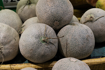 Baskets of pile fresh melons fruits display at the market.Farmer market department at supermarket store.