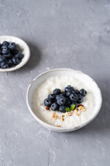 Rice porridge on coconut milk with blueberries on a gray background. Healthy breakfast, healthy food