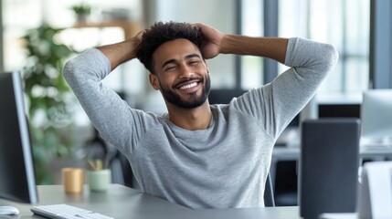 Obraz premium A Smiling Black Man Leans Back in His Chair at a Desk in an Office