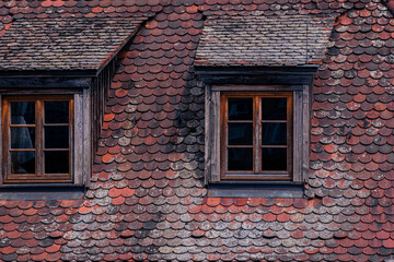 Old tiled roof with a dormer window. Roof of an old house in a town in Germany. Close-up photo of...