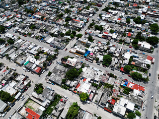 Aerial top-down view high altitude of slum a heavily populated urban informal settlement characterized by substandard housing and squalor poor living conditions streets and rusty metal home roof tops