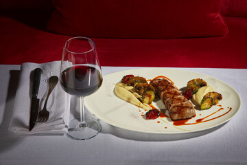 Steak and wine. Medium rare beef served with grilled vegetables and a glass of red wine. Stylish food on the table. Fine dinning