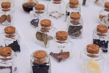 Small square glass jar with cap with medicinal herbs