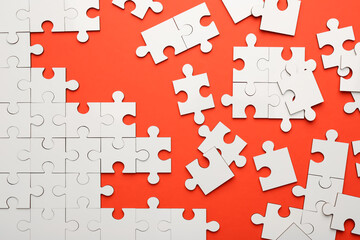 White puzzle pieces on red background, top view