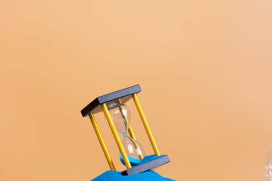 Hourglass is money sand of time, business blue sand in hourglass is adding more time in financial. Deadline extended time management hope concept to gold hour glass. Orange background sunset