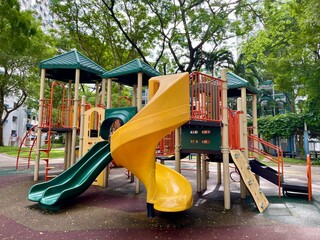 children's playground with a variety of play structures. The playground is surrounded by grass and trees