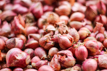 Pile of fresh Red Onion or Shallots in traditional bamboo basket. Kind of spices used in cooking. Food Ingredients.