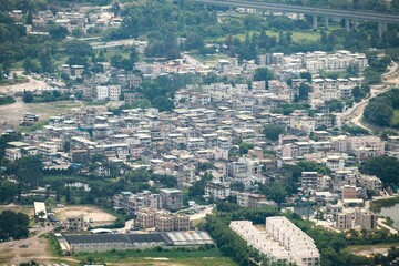 Obraz premium Aerial View of Dense Urban Residential Area with Surrounding Greenery