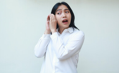 portrait of shocked sad asian young business woman wear white shirt posing hearing voice, eaved...