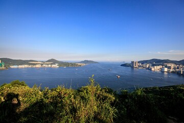 Serene Coastal View with City Skyline and Blue Sky