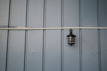 This Vintage Outdoor Lantern mounted on a striking Blue Wooden Wall offers a charming look