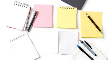 A white table with a variety of writing materials including pens, pencils