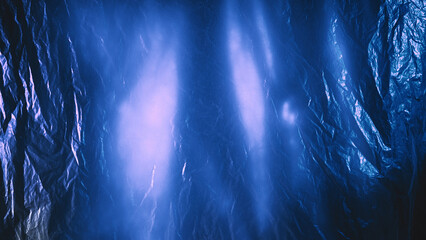 Crumpled foil. Wrinkled texture. Defocused shiny blue color distressed polyethylene film with lens...