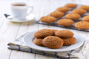 Low-calories oatmeal cookies and coffee on a light kitchen table, selective focus.
