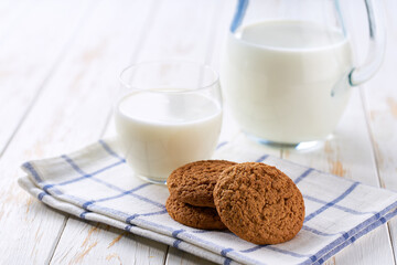 Low-calories oatmeal cookies and a jug of fresh milk on a light kitchen table,healthy breakfast.