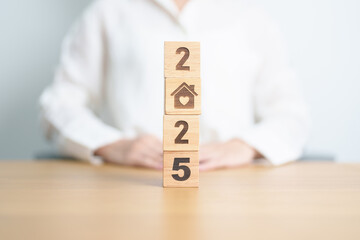 Happy New Year 2025 with Home and Heart block. Property investment, House Mortgage, Real Estate tax, homeless, donation, Financial and happy family concepts