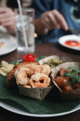 Set of Thai northern food served on a banana leaf, Nam prik num, Nam prik long, deep fried pork skin and Sai Aua. Tradition Northern Thai food.
