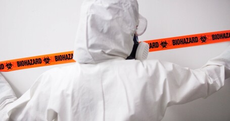 Person, crime and biohazard with tape, investigation and gas mask for hazard, fumes or danger by...
