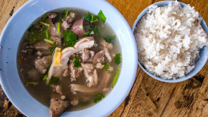 Breakfast soup with blue bowl on wooden table
