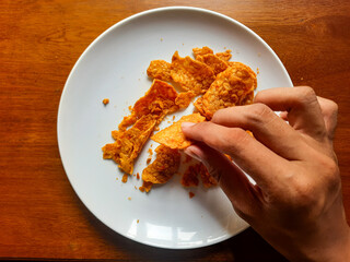 processed from tempeh, namely tempeh chips that are given spicy and salty seasoning on a white plate