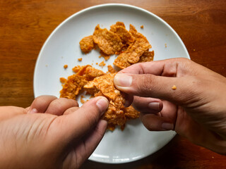processed from tempeh, namely tempeh chips that are given spicy and salty seasoning on a white plate