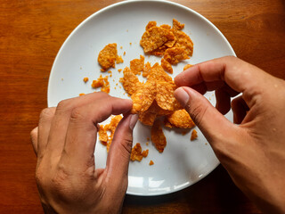 processed from tempeh, namely tempeh chips that are given spicy and salty seasoning on a white plate