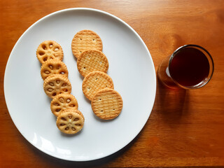 various kinds of biscuits that are usually eaten at breakfast accompanied by a glass of hot coffee on a white plate