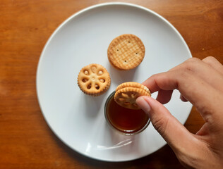 various kinds of biscuits that are usually eaten at breakfast accompanied by a glass of hot coffee on a white plate