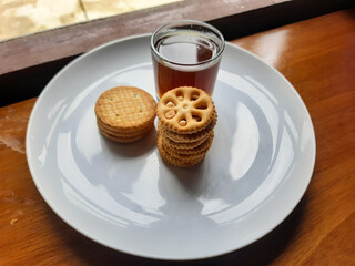 various kinds of biscuits that are usually eaten at breakfast accompanied by a glass of hot coffee on a white plate